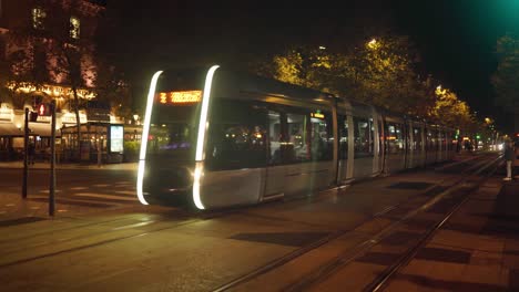Modern-city-electric-tram-travelling-through-city-centre-full-of-passengers