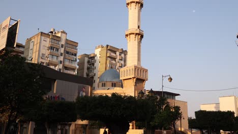 panning-shot-of-modern-minaret-above-old-arab-town-in-Tripoli,-Northern-Lebanon