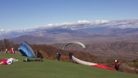 Group-of-paragliders-in-Krushevo,-Macedonia,-prepares-for-takeoff,-soaring-into-the-sky-for-an-exhilarating-flight