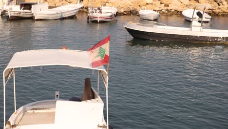 Bandera-Del-Líbano-Ondeando-Al-Viento-En-Un-Pequeño-Barco-Pesquero-En-El-Puerto-Mediterráneo-Cerca-De-Trípoli,-En-El-Norte-Del-Líbano