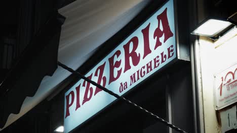 Famoso-Cartel-De-Pizzería-Da-Michele,-Vista-Nocturna-De-Nápoles,-Italia