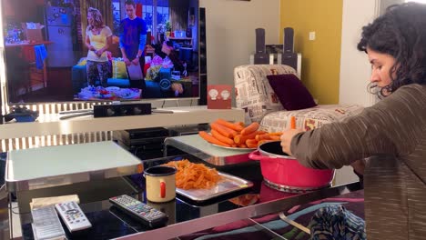 Shredded-carrot-using-metal-steel-grater-at-home-in-Iran-Tehran-A-Persian-woman-work-at-home-while-watching-TV-during-winter-season-in-apartment-concept-of-house-keeping-work-couple-life-relationship