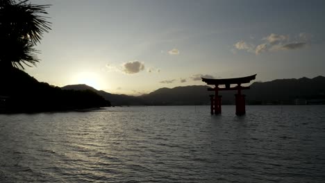 Kiefernzweig-Bewegt-Sich-Mit-Silhouettenansicht-Des-Schwimmenden-Grand-Torii-Tors-Während-Des-Sonnenuntergangs-Im-Hintergrund-In-Itsukushima
