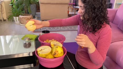 A-woman-is-cutting-quince-to-small-pieces-to-cook-with-sugar-on-top-of-oven-fire-slow-food-Persian-cuisine-then-mix-with-rose-water-extract-and-cardamom-seeds-to-marinate-jam-red-slice-of-delicious