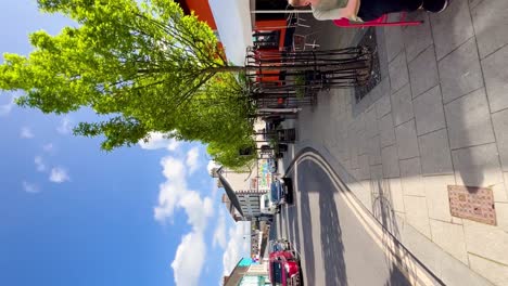 Sunny-Conversations:-Vertical-Video-of-Street-Life-in-Graiguenamanagh,-County-Kilkenny,-with-People-Talking-at-a-Table-on-a-Beautiful-Day