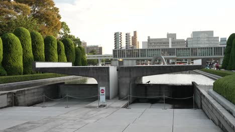 Blick-Auf-Die-Flamme-Des-Friedens,-Das-Denkmal-Für-Die-Opfer-Der-Atombombe-Mit-Dem-Kenotaph-Der-Hiroshima-Opfer-Im-Hintergrund