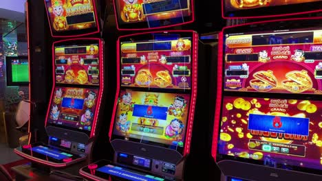 Asian-themed-casino-digital-slot-machines,-red-flashing-lights,-tilting-up-view
