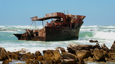 Rusted-old-shipwreck-of-Meisho-Maru-No-38-stuck-on-rocky-coastline,-Agulhas