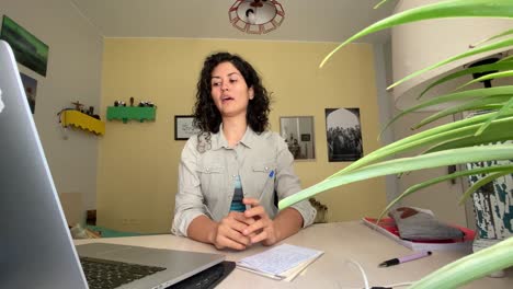 Curly-hair-woman-in-Iran-are-recording-video-for-online-class-webinar-in-Tehran-Iran-Persian-language-and-learning-concept-in-online-course-class-work-at-home-and-decoration-in-yellow-design-laptop