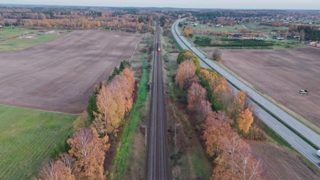 Birds-eye-drone-shot-of-country-fields-with-trees-and-highway-in-beautiful-fall