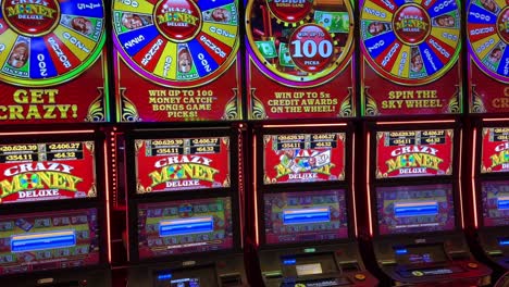 Casino-Wheel-of-Fortune-slot-machine-colorful-flashing-lights,-tilting-up-view