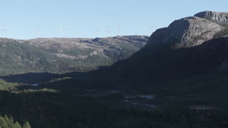 Hildremsvatnet,-Trondelag-County,-Norway---The-Sight-of-Windmills-Nestled-Within-a-Mountain-Range,-Enveloped-by-Abundant-Greenery---Aerial-Pan-Right