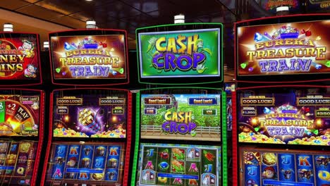 Casino-floor-with-different-types-of-colorful-slot-machines,-tilting-up-view