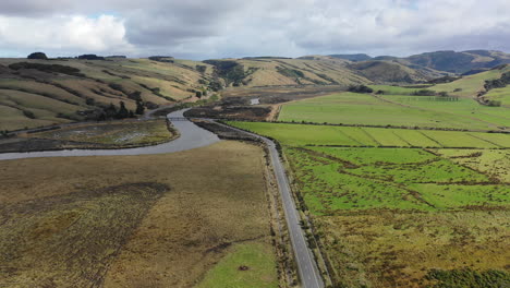 Luftaufnahme-Einer-Straße,-Die-Sich-Durch-Patchwork-Felder-In-Der-Malerischen-Ländlichen-Landschaft-Neuseelands-Schlängelt
