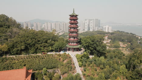 Nanling-Tower,-gracefully-tilting-down-to-unveil-the-backdrop-of-Nansha-Tin-Hau-Palace