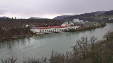 Wasserkraftwerk-Beznau-Schweiz-Mit-Kernreaktor-Im-Hintergrund,-Drohnen-Truck-4k