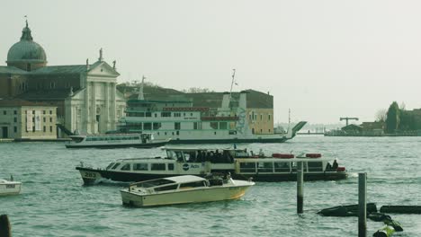 Varios-Tipos-De-Barcos-Pasando-Con-La-Pintoresca-Venecia-Al-Fondo.