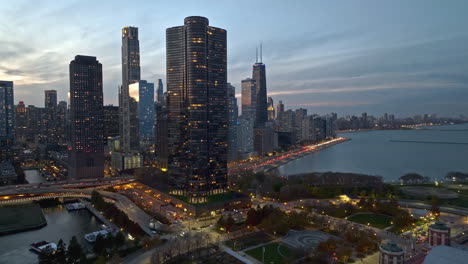 Aerial-view-over-the-Polk-Bros-Park,-toward-traffic-in-front-of-Streeterville,-fall-dusk-in-Chicago