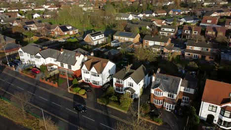 Aerial-view-expensive-British-middle-class-houses-panning-across-rural-suburban-neighbourhood