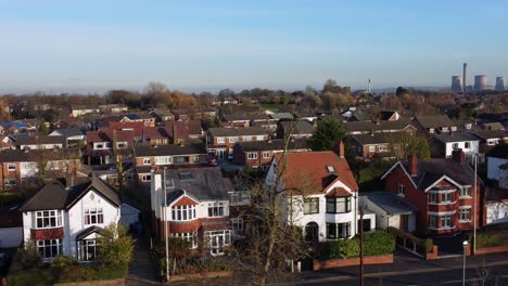 Aerial-view-expensive-British-middle-class-houses-in-rural-suburban-neighbourhood-rising-over-rooftop-skyline