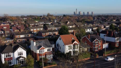 Aerial-view-expensive-British-middle-class-houses-in-rural-suburban-neighbourhood-under-fiddlers-ferry-power-station-skyline