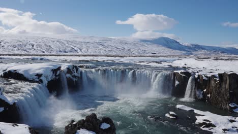 Reveal-of-crystal-clear-water-pool-of-Godafoss-waterfall-during-blue-sky-day