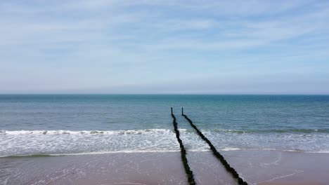 Long-groyne-reaching-into-the-sea-at-a-beautiful-beach-in-the-netherlands