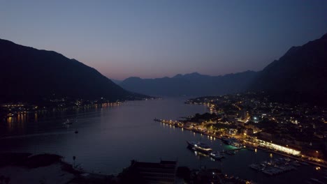 Nachtluftdrohne-Der-Stadt-Kotor-In-Montenegro-Mit-Blick-Auf-Meer-Und-Berge