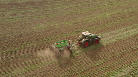 Profile-follow-aerial-shot-of-a-tractor-ploughing-a-field