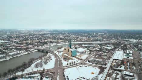Toma-De-Establecimiento-Museo-Canadiense-De-Derechos-Humanos-Urbano-Winnipeg-Manitoba-Canadá-Centro-Rascacielos-Edificios-En-La-Ciudad-Paisaje-Nublado-Horizonte-Nevando-Invierno-Drone-4k-Tiro-Girando-órbita