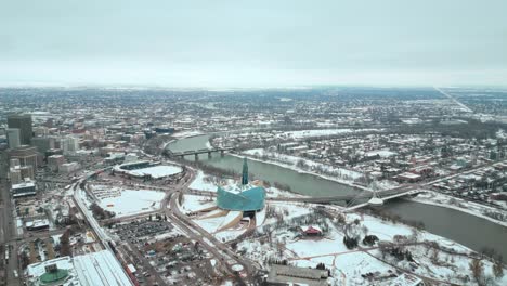 Gran-Establecimiento-Gran-Angular-Tiro-Completo-Museo-Canadiense-De-Derechos-Humanos-Urbano-Winnipeg-Manitoba-Canadá-Centro-Rascacielos-Edificios-En-La-Ciudad-Paisaje-Nublado-Horizonte-Nevando-Invierno-Drone-4k-Tiro