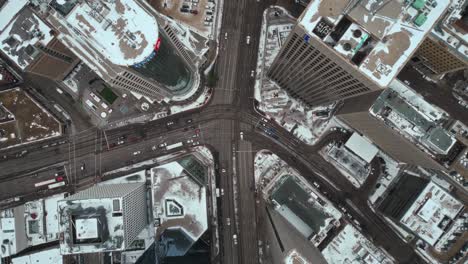Descending-Overhead-Vehicle-Traffic-4K-Time-lapse-Winter-Drone-Shot-Canadian-Roadway-Trans-Highway-One-Intersection-Portage-Avenue-and-Main-Street-Capital-City-Downtown-Winnipeg-Manitoba-Canada