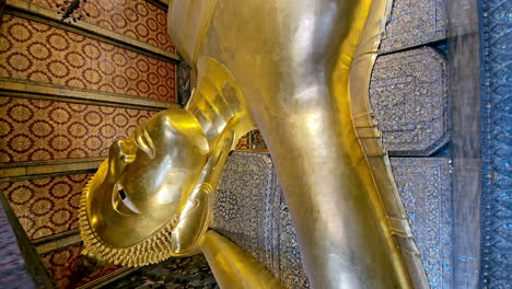 Vertikale-Orbitalaufnahme-Von-Unten-Einer-Statue-Eines-Liegenden-Buddhas-In-Einem-Tempel-In-Bangkok,-Thailand
