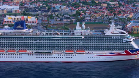 Side-trucking-pan-along-Caribbean-cruise-ship-docked-at-port-in-early-morning
