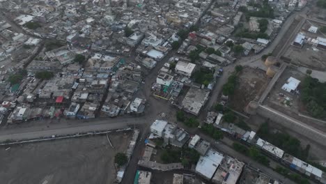 Aerial-drone-zoom-in-shot-over-the-city-houses-in-Umerkot-city,-Tharparkar,-Pakistan-on-a-cloudy-day