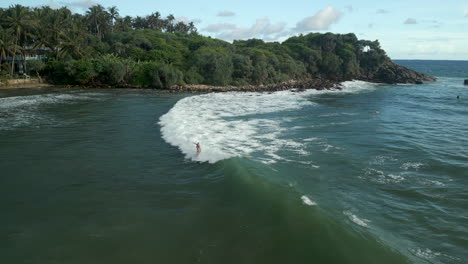 Aerial-Drone-Shot-of-Caucasian-Female-Surfer-Catching-and-Riding-a-Wave-and-Falling-in-Southern-Sri-Lanka