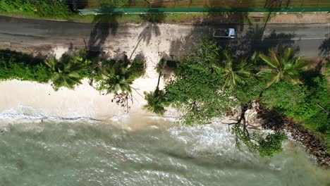 Drone-shot-of-climate-change,-global-warming,-high-tide-that-sea-level-rise-until-the-main-road,-passing-cars-over-sand,-anse-royale-beach,-Mahe,-Seychelles-30fps-3