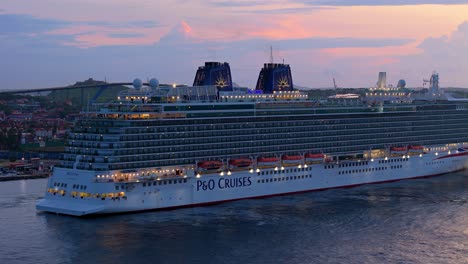 Side-angle-rising-view-of-cruise-ship-liner-docked-in-Caribbean-port-at-blue-hour