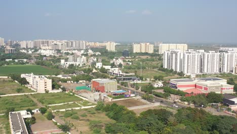 Rajkot-city-aerial-view-Drone-camera-moving-to-the-side,-showing-large-trees-surrounding-the-talkies
