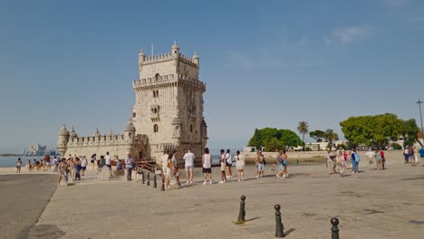 Tourists-take-a-stroll-near-the-Belem-Tower-in-Lisbon,-Portugal