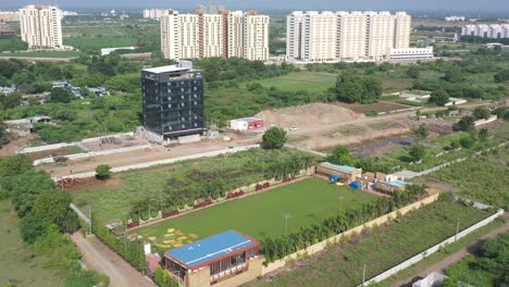 Rajkot-city-aerial-view-Camera-moving-from-above-party-plot-towards-high-rise-building-under-construction