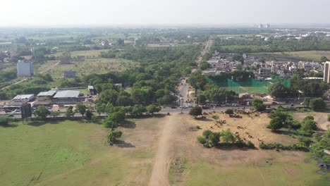 Rajkot-city-aerial-view-drone-camera-moving-forward,-where-there-is-a-traffic-jam,-box-cricket-is-behind-the-road