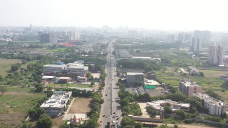 Rajkot-city-aerial-view-flying-between-Kalavad-Road,-with-Cosmoplex-Talkies-visible-on-the-left