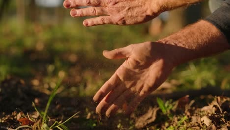 Gardener-close-up-clapping-dirt-off-hands-in-slow-motion,-sunset-farming