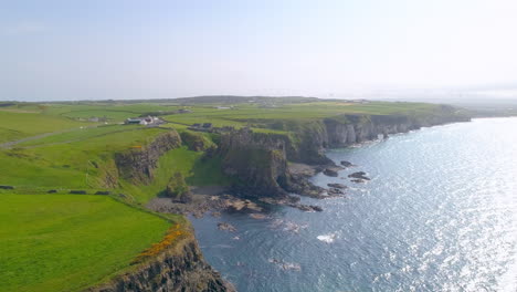 Dunluce-castle-wide-landscape-aerial-track-from-sea-to-land