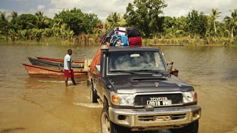 The-all-terrain-off-road-vehicle-with-backpack-leaving-the-weak-river-ferry-boat-made-of-pirogues