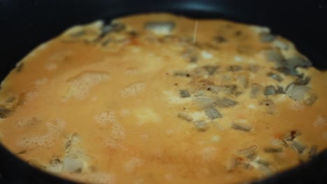 Eine-Detaillierte-Nahaufnahme,-Bei-Der-Man-Etwas-Salz-Und-Pfeffer-Auf-Ein-Ognion-Ei-Omelett-Streut-Und-Ein-4K-Frühstücksvideo-Erstellt
