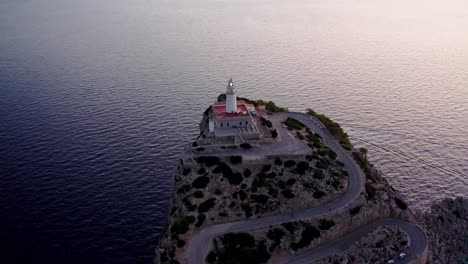 Historic-old-lighthouse-on-the-edge-of-cliff-overlooking-the-sea,-aerial-drone