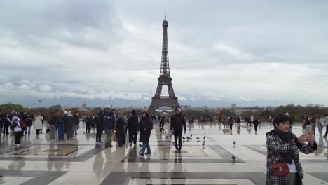 Asians-Female-Tourist-Stands-in-Trocadero-Square-and-Takes-Pictures-of-Herself-in-Front-of-Eiffel-Tower