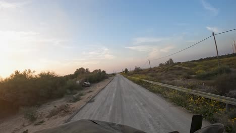 Driving-army-vehicle-in-Gaza-Strip,-abandoned-car-by-the-road